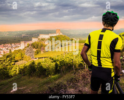 Cyclist admires from the hill the Soave castle views. Stock Photo