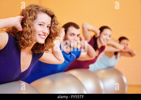 Happy young group doing fitness exercises in health club Stock Photo