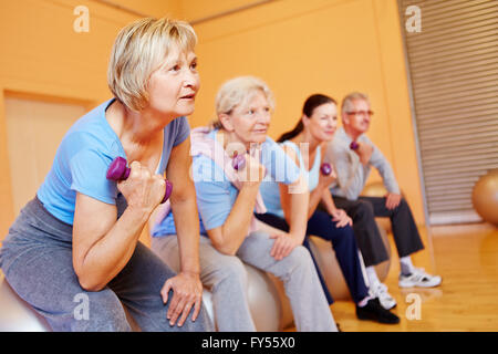 Group of senior people doing back training exercises in a gym Stock Photo