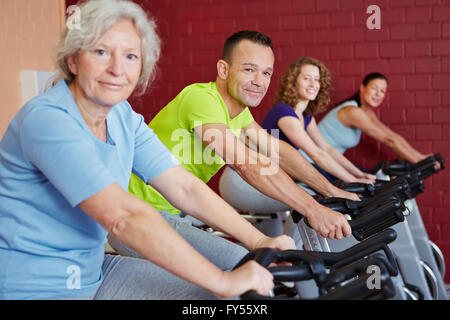 Group doing fitness training with spinning bikes in a health club Stock Photo