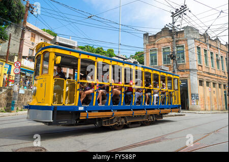 RIO DE JANEIRO - MARCH 28, 2016: Tourists ride the new version of the iconic bonde tram in the heart of Santa Teresa. Stock Photo