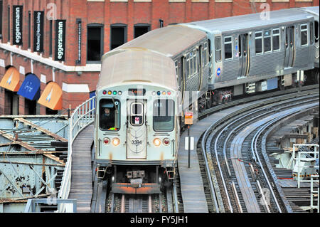 A CTA Brown Line train as it negotiates a curve on elevated tracks in Chicago's  River North neighborhood. Chicago, Illinois, USA. Stock Photo