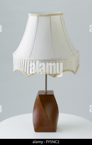 Table lamp on end table against gray background Stock Photo