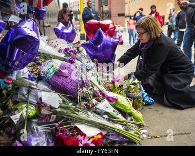Minneapolis, MN, USA. 22nd Apr, 2016. A woman lays flowers at a memorial for Prince in front of 1st Ave in Minneapolis. Thousands of people came to 1st Ave in Minneapolis Friday, to mourn the death of Prince, whose full name is Prince Rogers Nelson. 1st Ave is the nightclub the musical icon made famous in his semi autobiographical movie ''Purple Rain.'' Prince, 57 years old, died Thursday, April 21, 2016, at Paisley Park, his home, office and recording complex in Chanhassen, MN. Credit:  Jack Kurtz/ZUMA Wire/Alamy Live News