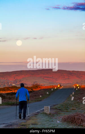 Flintshire, North Wales, UK Weather- Artic air pushes south over the UK leaving frost overnight, a walker enjoying sunrise and setting moon over Clwydian Hills on what could be a beautiful day, Flintshire, North Wales, UK. Stock Photo