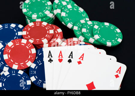 Playing card and fiches on black table, four a kind aces Stock Photo