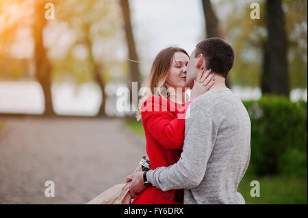 Marriage proposal. Kissed girl and boyfriend with bouquet of flowers Stock Photo