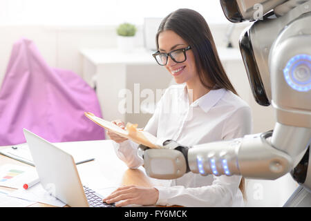 Cheerful girl getting package from the robot Stock Photo