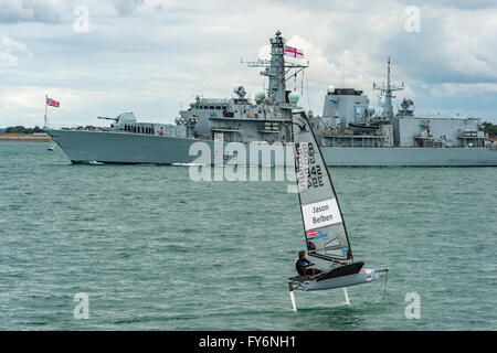 GB's Jason Belben passing British frigate on his return to harbour during Racing on Day 1 of America's Cup Portsmouth 2015 Stock Photo