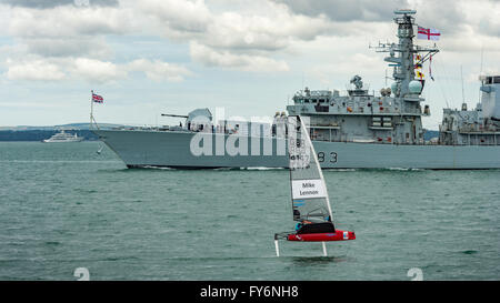 GB's Mike Lennon passing British frigate on his return to harbour during Racing on Day 1 of America's Cup Portsmouth 2015 Stock Photo