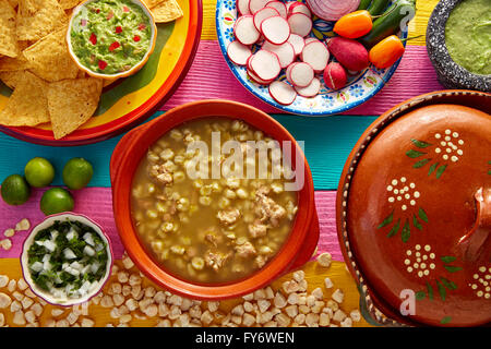 Green Pozole verde with blanco mote corn and ingredients on colorful table Stock Photo