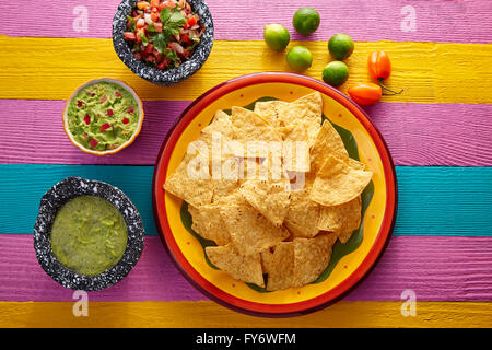 Nachos tortilla chips with mexican sauces on colorful table Stock Photo