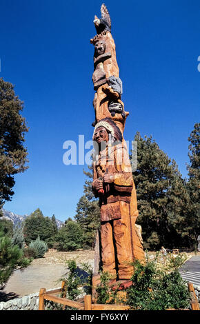 An historic totem pole known as the Idyllwild Tree Monument was carved by chainsaw artist Jonathan LeBenne in 1989 and became became a landmark in the center of the beautiful wooded mountain village of Idyllwild, California, USA. Crafted from a 400-year-old ponderosa pine tree, the 50-foot (15-meter) totem depicted an American Indian, a raccoon, squirrel, mountain lion, and an eagle. Unfortunately, invasive bugs and woodpeckers destroyed the wooden monument over time and it fell in pieces. The totem was replaced in 2010 by a much shorter and thicker tree carving of wild animals. Historic photo Stock Photo