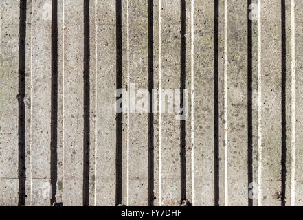 Weathered and stained grey concrete wall with vertical pattern for background Stock Photo
