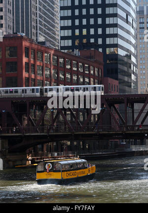 A yellow Chicago water taxi and CTA elevated train cross the Lake Street Bridge along the Chicago River in Chicago, IL, USA Stock Photo