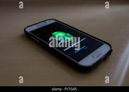 Android robot graphic with the message in Portuguese which reads "Installing system update" is seen on smartphone screen Stock Photo