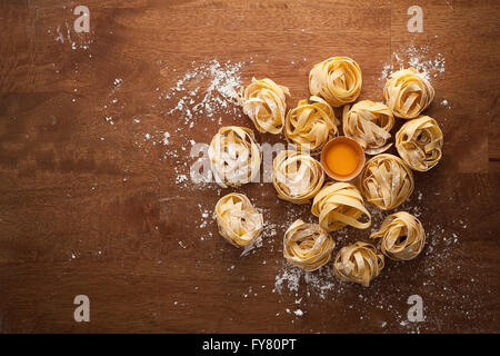 fettuccine pasta italian food still life rustic flat lay wood background tagliatelle alfredo yolk Stock Photo