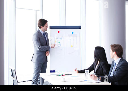 Workers at business meeting looking at presentation of financial reports in modern office Stock Photo
