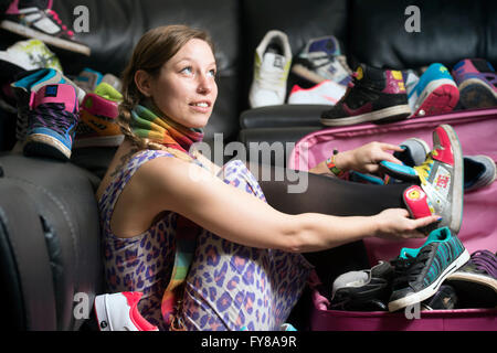 A young girl with a large collection of trainers UK Stock Photo