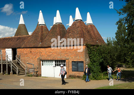 UK, Kent, Sissinghurst Castle, visitors walking past Oast Houses in farmyard Stock Photo