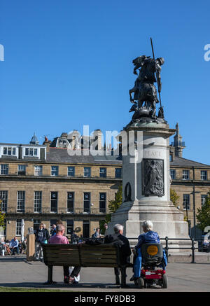 Enjoying the sunshine beside the War Memorial in John Dobson's Old Eldon Square, Newcastle Stock Photo