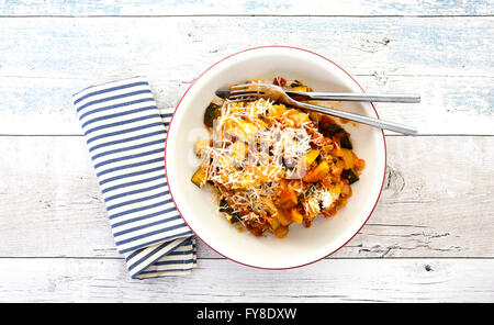 Traditional vegetable ratatouille on a rustic wooden background with blue and white striped napkin Stock Photo