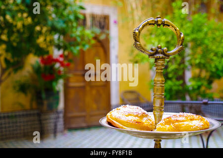 Two pastries on an oriental serving tray in a Moroccan interior setting Stock Photo