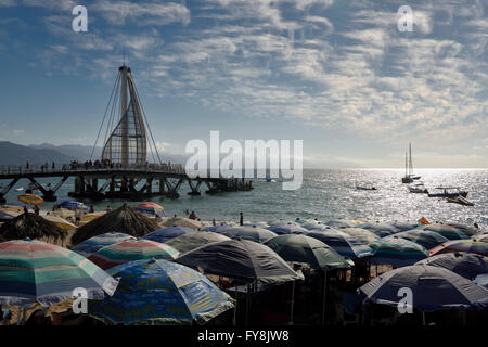 Beach umbrellas on Los Muertos beach at the Pier and Sierra Madre mountains Puerto Vallarta Mexico Stock Photo