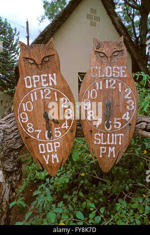 Wooden signs about opening and closing hours in the rest camps at Kruger National Park, South Africa Stock Photo