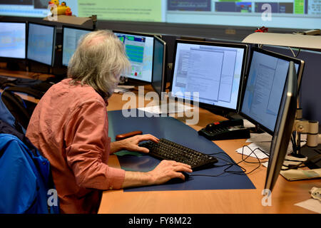 Physicist at computer monitors in control room of ATLAS detector at CERN. Stock Photo