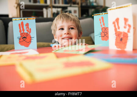 Happy little boy with self-made Easter cards at home Stock Photo