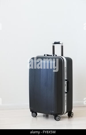 Large family polycarbonate luggage on white wooden background. Stock Photo
