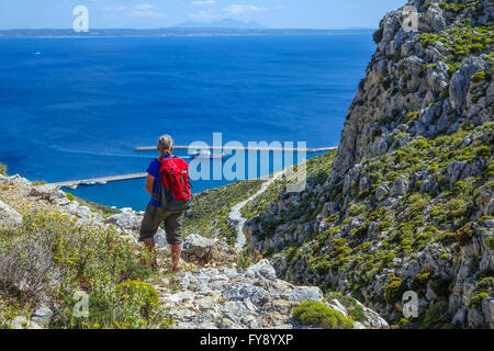 Lone female walker on Italian Road footpath, Kalymnos, Greece Stock Photo