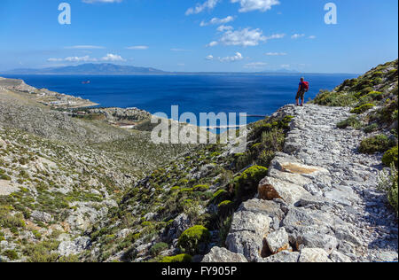 Lone female walker on Italian Road footpath, Kalymnos, Greece Stock Photo