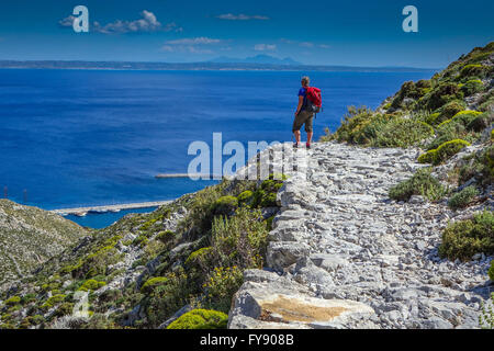 Lone female walker on Italian Road footpath, Kalymnos, Greece Stock Photo