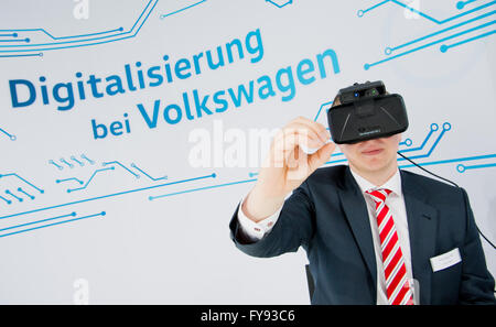Hanover, Germany. 23rd Apr, 2016. A Volkswagen staff member wears the 'Oculus Rift' virtual reality glasses at the exhibition booth of Volkswagen at Hanover fair in Hanover, Germany, 23 April 2016. The world's biggest industry fair Hanover Messe is being opened by US-President Obama on 24 April. The United States of America are this year's partnering country. PHOTO: JULIAN STRATENSCHULTE/dpa/Alamy Live News Stock Photo