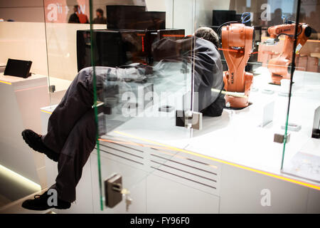 Hanover, Germany. 23rd Apr, 2016. A staff member adjusts a robot model at robotics manufacturer KUKA's stand prior to the 2016 Hanover Industrial Trade Fair in Hanover, Germany, on April 23, 2016. The world's leading fair for industrial technology, attended by about some 5000 exhibitors, would take place from April 25 to 29 with the United States as this year's partner country. © Zhang Fan/Xinhua/Alamy Live News Stock Photo
