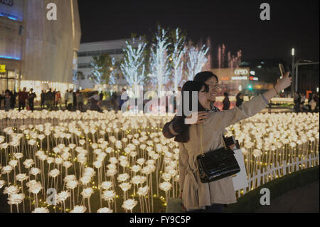 Chengdu, China's Sichuan Province. 24th Apr, 2016. People take selfies with rose-shaped lamps at a shopping mall in Chengdu, capital of southwest China's Sichuan Province, April 24, 2016. Credit:  Jinma Mengni/Xinhua/Alamy Live News Stock Photo