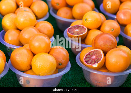 Market stall selling blood oranges in plastic bowls Stock Photo