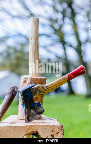 A hand axe on a wooden block after being used to shape a handle.