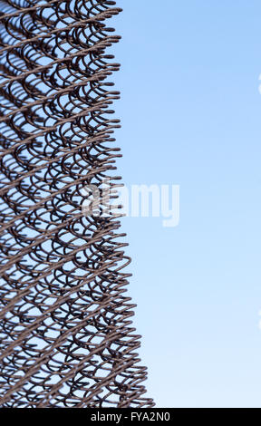 Old aged and unmaintained chain link fencing set against a blue sky background. Vertical composition with copy space area for DI Stock Photo