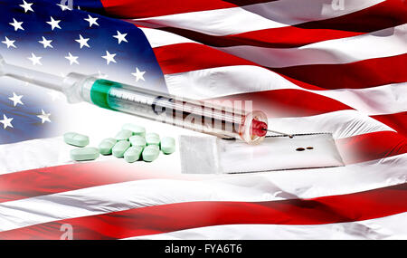 Heroin in a hypodermic needle  with packets of heroin powder, and pills on an American Flag Stock Photo