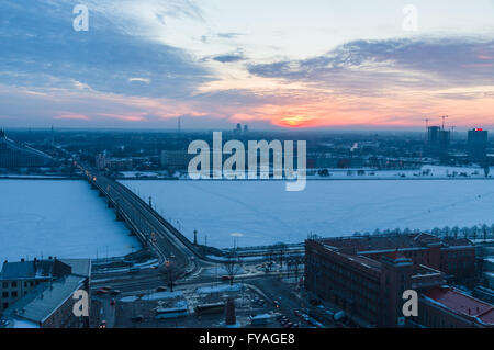 Winter-time sunset over Daugava river and Stone bridge. Construction of the bridge ended in 1957. Stock Photo