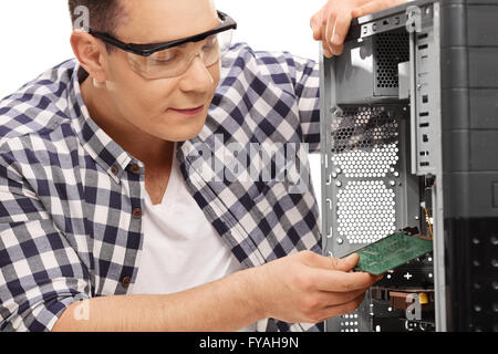 Young PC technician assembling a desktop computer isolated on white background Stock Photo