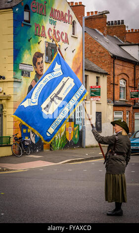 Female Irish Republican carrying Cumann na mBan flag on Belfast Falls Road during 1916 Easter Rising parade. Stock Photo