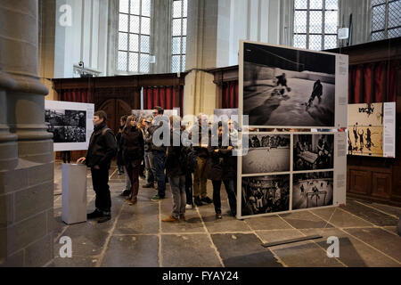 Visitors view winning pictures taken by various photojournalists from the photojournalism category of the World Press Photo contest, as they are displayed inside the Nieuwe Kerk church in Amsterdam Netherlands. The exhibition presents the winning photographs of the latest edition of the annual international photojournalism contest, the longest-running and most prestigious in the world. Stock Photo