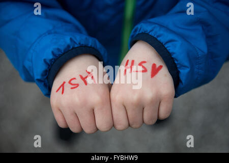 Hamburg, Germany. 18th Apr, 2016. A young Hamburg supporter shows his hands that read 'HSV' during a training session of German Bundesliga soccer club on the training grounds next to the Volksparkarena in Hamburg, Germany, 18 April 2016. Photo: CHRISTIAN CHARISIUS/dpa/Alamy Live News Stock Photo