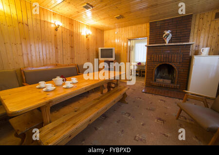 Apartment interior with wooden big table and fireplace Stock Photo