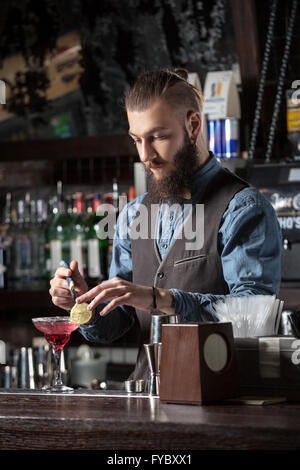 Happy young barman serving cocktail at the bar. Stock Photo