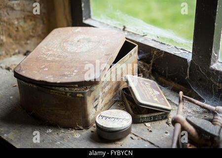 Old tins on a windowsill inside the stables in the village of Tyneham, Dorset, which was abandoned during the second world war Stock Photo